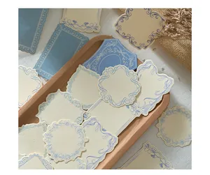 Close-up of vintage embossed paper labels with blue floral borders for journaling
