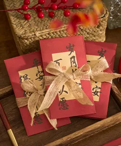 Enveloppes rouges du Nouvel An chinois avec calligraphie et détails de ruban en jute