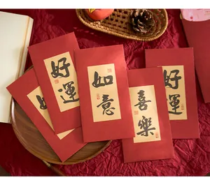 Vue détaillée des enveloppes rouges avec calligraphie chinoise traditionnelle sur tissu rouge