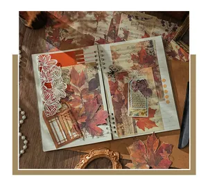 Macro shot of vintage maple leaf scrapbooking paper used in a creative journal collage.