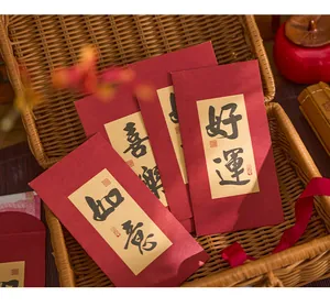 Vue rapprochée d'enveloppes rouges du Nouvel An chinois avec calligraphie dans un panier.