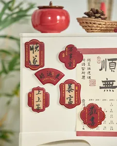 Close-up of Chinese style epoxy fridge magnets with calligraphy blessings on white surface