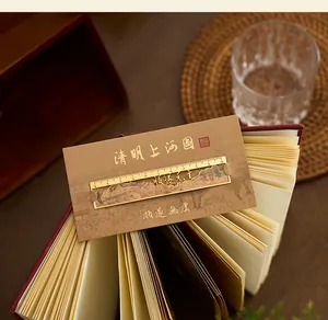 Close-up view of golden metal hollow ruler bookmark with classical Chinese calligraphy text