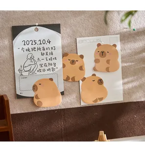 Primo piano di simpatici post-it a forma di capibara su una bacheca di feltro grigio