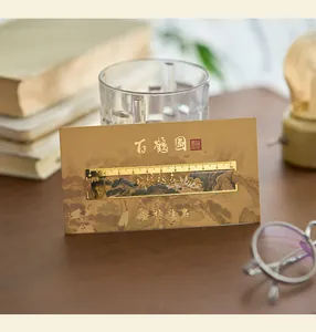 Classical Chinese style hollow brass bookmark ruler displayed on a warm wooden desk