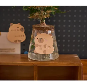 Dettaglio di un simpatico post-it a forma di capibara a fumetti attaccato a un vaso di vetro
