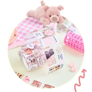 Detailed view of pink Korean style DIY sticker tape roll with cute plush pig prop