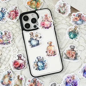 Watercolor perfume bottle stickers decorating a white phone case on lace cloth