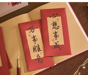 Vue détaillée d'enveloppes rouges artistiques avec calligraphie chinoise sur carnet