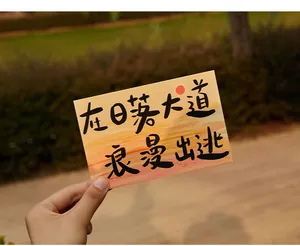 Gros plan d'une carte postale avec motif coucher de soleil et citation romantique
