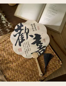 Detalle del abanico de estilo antiguo en forma de flor con caligrafía y borla