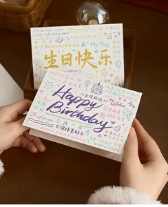 Macro view of white birthday greeting card featuring colorful hand-drawn illustrations and text