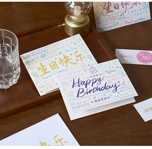 Detail view of colorful birthday greeting cards with artistic calligraphy and illustrations