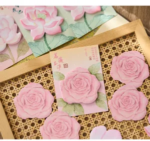 Detailed view of pink rose and lotus flower shaped sticky notes on a rattan surface