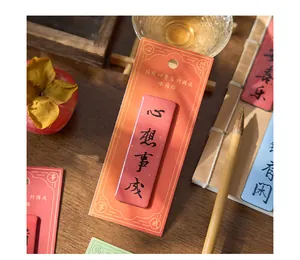 Close-up of a red Chinese style fridge magnet with blessing calligraphy on a wooden table.