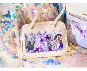 Close-up of a beige DIY itabag filled with cute anime badges and purple decorations