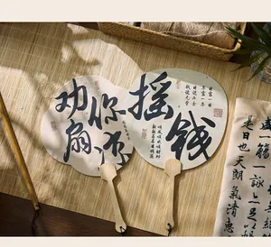 Primer plano de abanicos chinos tradicionales con caligrafía y mangos de bambú en ambiente Zen