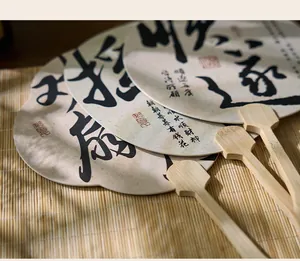 Detalle de cerca de abanicos chinos tradicionales con caligrafía sobre una estera de bambú