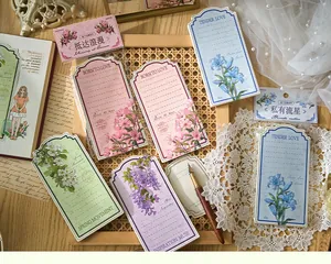 Detailed view of floral art memo pads with vintage stationery and lace decoration