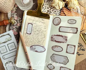 Detail view of vintage floral label stickers on a minimalist notebook with retro props