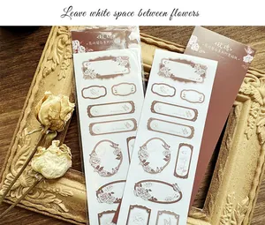 Macro view of vintage floral sticker labels for journaling on wooden background