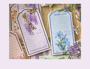 Detail of vintage floral memo pads with lavender and blue lily illustrations on wood