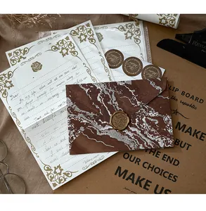 Détail macro du papier à lettres vintage doré et enveloppe marbrée avec sceau de cire