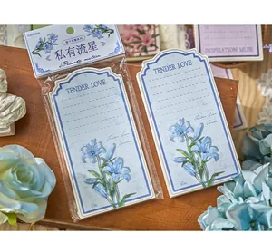 Detail shot of blue floral lily illustration memo pad with vintage packaging