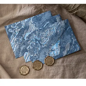 Vue détaillée d'enveloppes marbrées bleues avec des sceaux en cire dorée vintage.