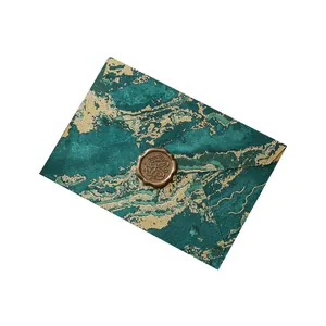 Vintage emerald green and gold marbled invitation envelope with a classic wax seal stamp