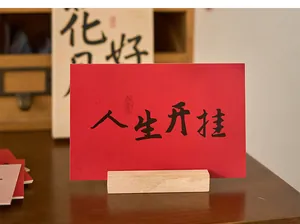 Detailansicht der roten Grußkarte im chinesischen Stil mit Kalligraphie auf Holzständer