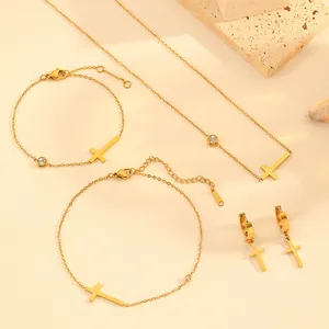 Detail view of a gold-plated titanium steel jewelry set with elegant cross pendants and gems