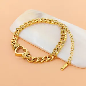 Vue détaillée d'un bracelet en maille gourmette avec breloque cœur en acier inoxydable doré.