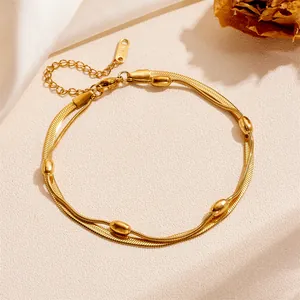 Close-up detail of golden stainless steel double-layer bead bracelet with extension chain
