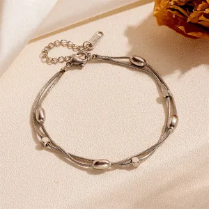 Close-up detail of silver double-layer bracelet with smooth beads and geometric spacers