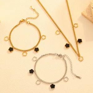Detail view of gold and silver stainless steel necklace and bracelets with flower charms