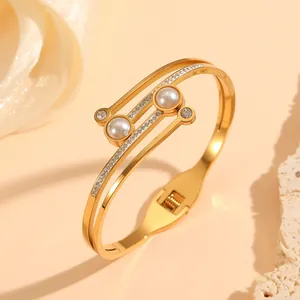 Close-up of elegant gold stainless steel bangle with inlaid pearls and rhinestones