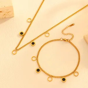 Detailed view of gold stainless steel necklace and bracelet set with round charms