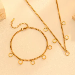 Detail view of gold stainless steel necklace and bracelet set with shell circular charms.