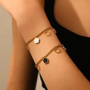 Gold titanium steel floral charm bracelet set worn on wrist close-up view