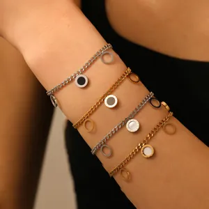 Close-up of stainless steel chain bracelets featuring roman numeral disc charms