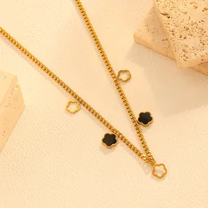 Close-up of a 18k gold plated stainless steel necklace with black flower charms