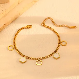 Close-up macro view of a gold-plated flower charm bracelet featuring white shell inlays.