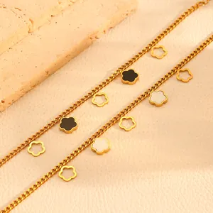 Close-up view of gold stainless steel necklace with black and shell flower charms