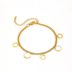 Detail of gold stainless steel bracelet with white shell flower charms and hollow design.