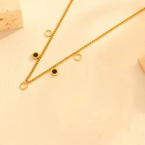 Close-up of gold stainless steel necklace with black enamel and hollow circle charms
