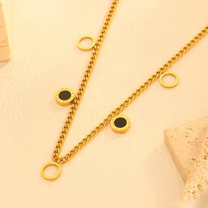 Detail of gold stainless steel necklace featuring black circles with Roman numerals.