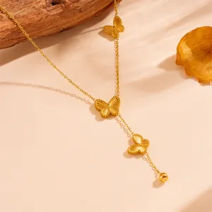 Gros plan d'un collier en acier titane doré avec des breloques papillon détaillées
