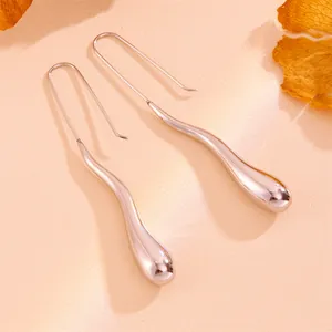 Elegant macro view of rose gold teardrop earrings with a minimalist long hook design