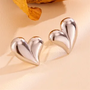 Macro shot showing the high-polish finish of vintage silver heart-shaped stud earrings.
